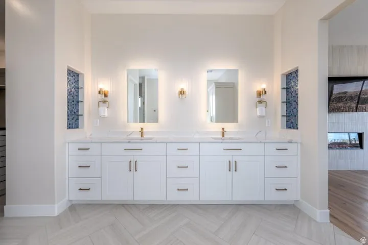 Full bathroom with double vanity, parquet floors, and a fireplace
