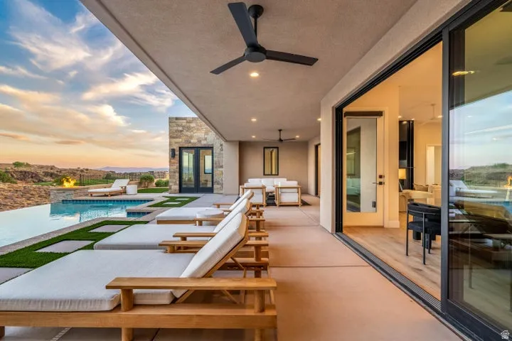 Balcony with view of pool area, a ceiling fan, and an outdoor hangout area