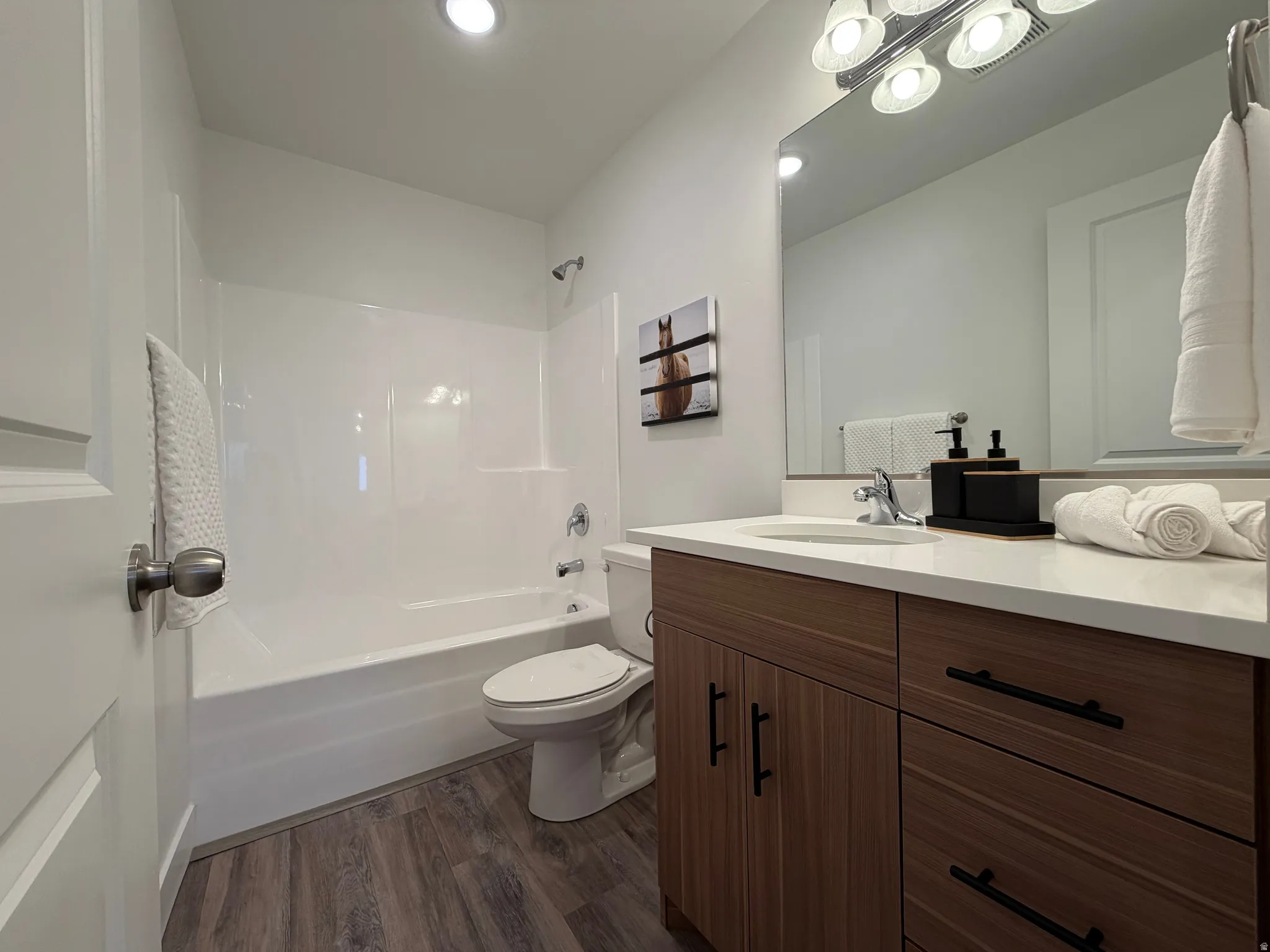 Full bath with vanity, dark wood-style flooring,  shower combination, and recessed lighting