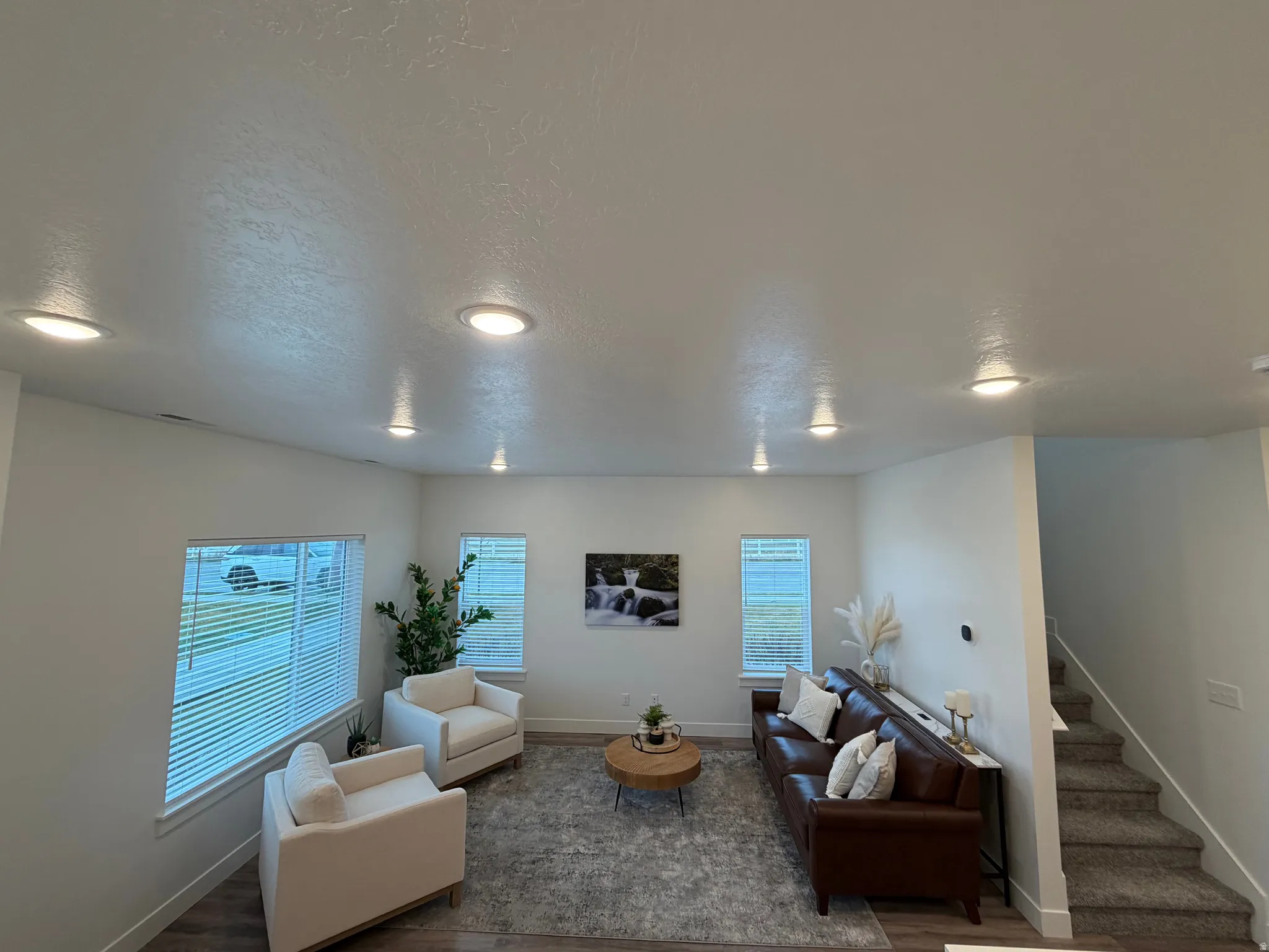 Living area with a textured ceiling and dark wood-type flooring