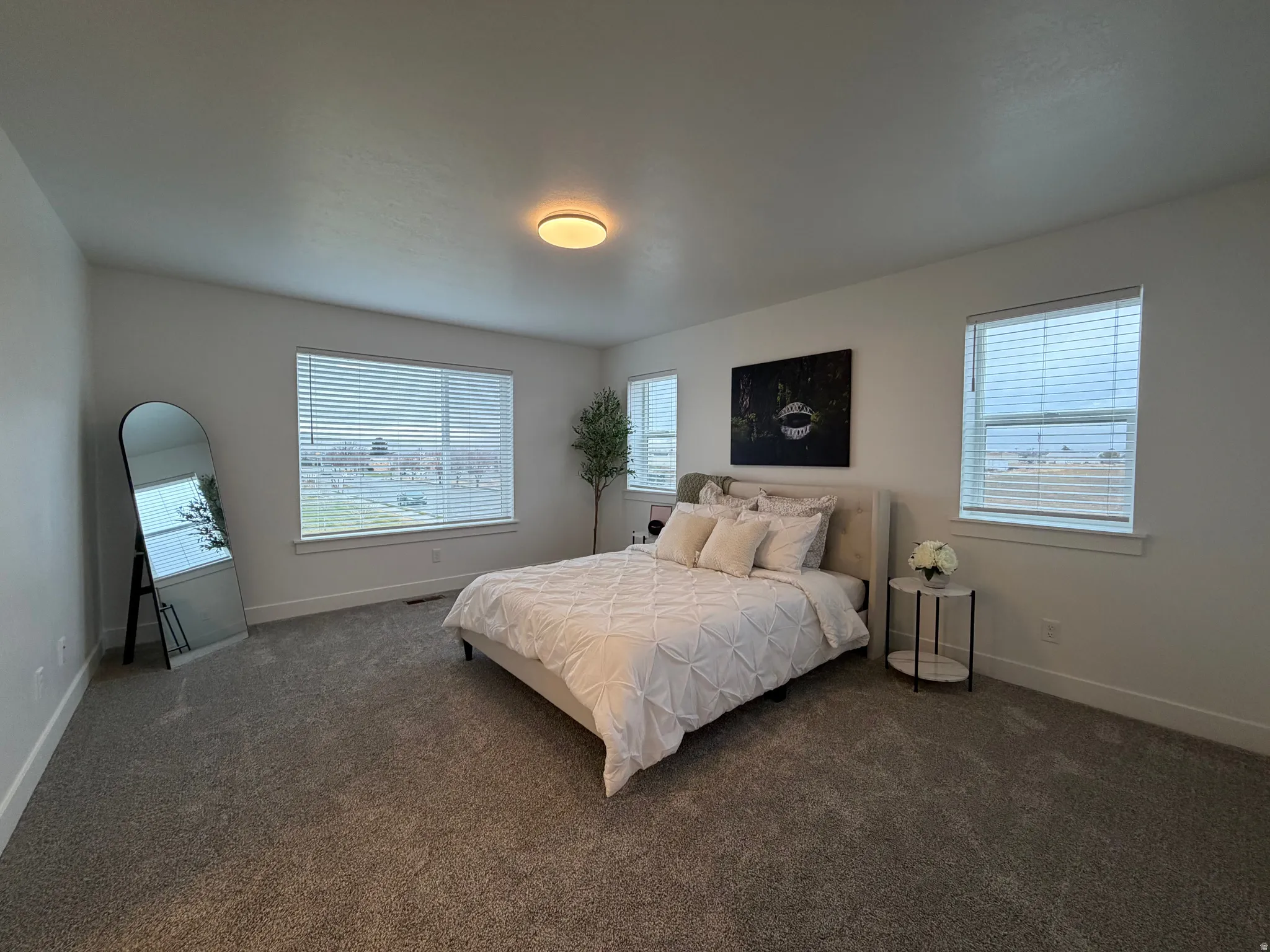 Spacious Premier bedroom featuring multiple windows and dark carpet