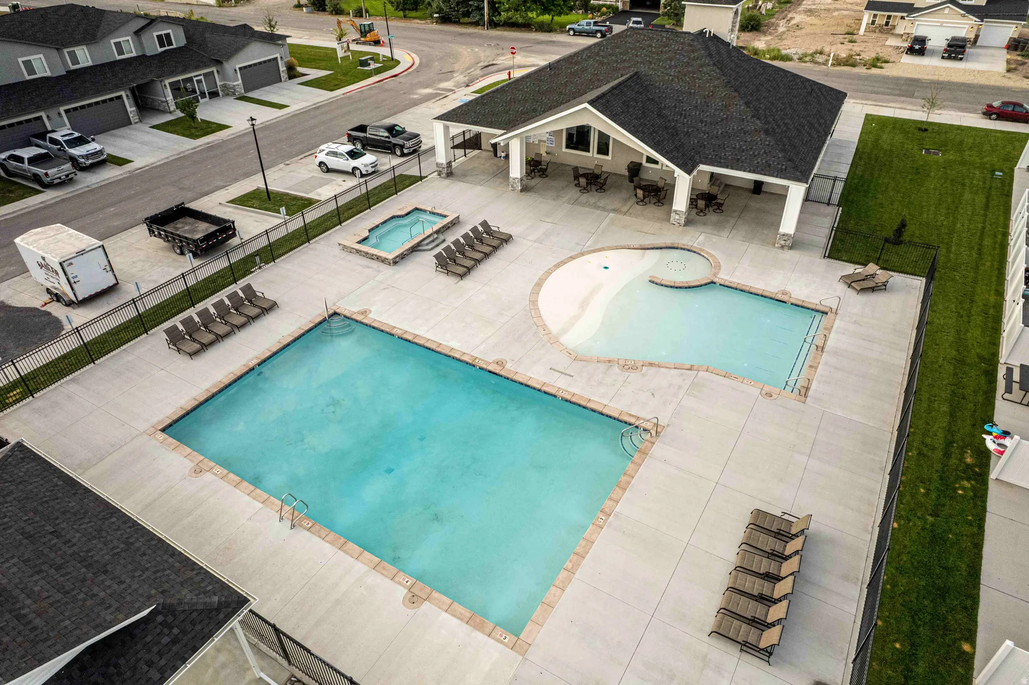 Community pool with a patio, outdoor dining space, and a hot tub