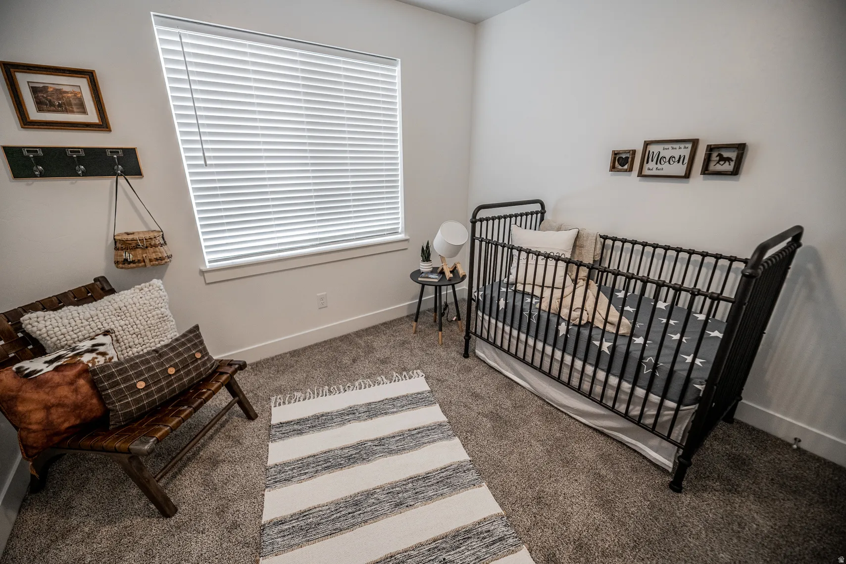 Bedroom featuring light carpet and a crib