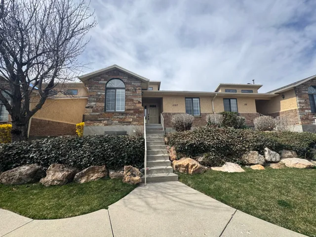 View of front facade featuring stone siding and a front yard
