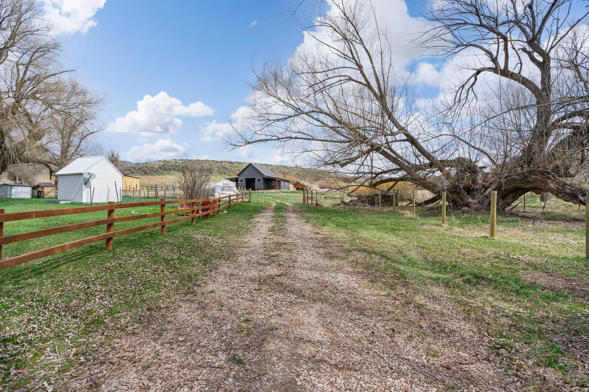 View of dirt / gravel driveway with a view of countryside and a barn
