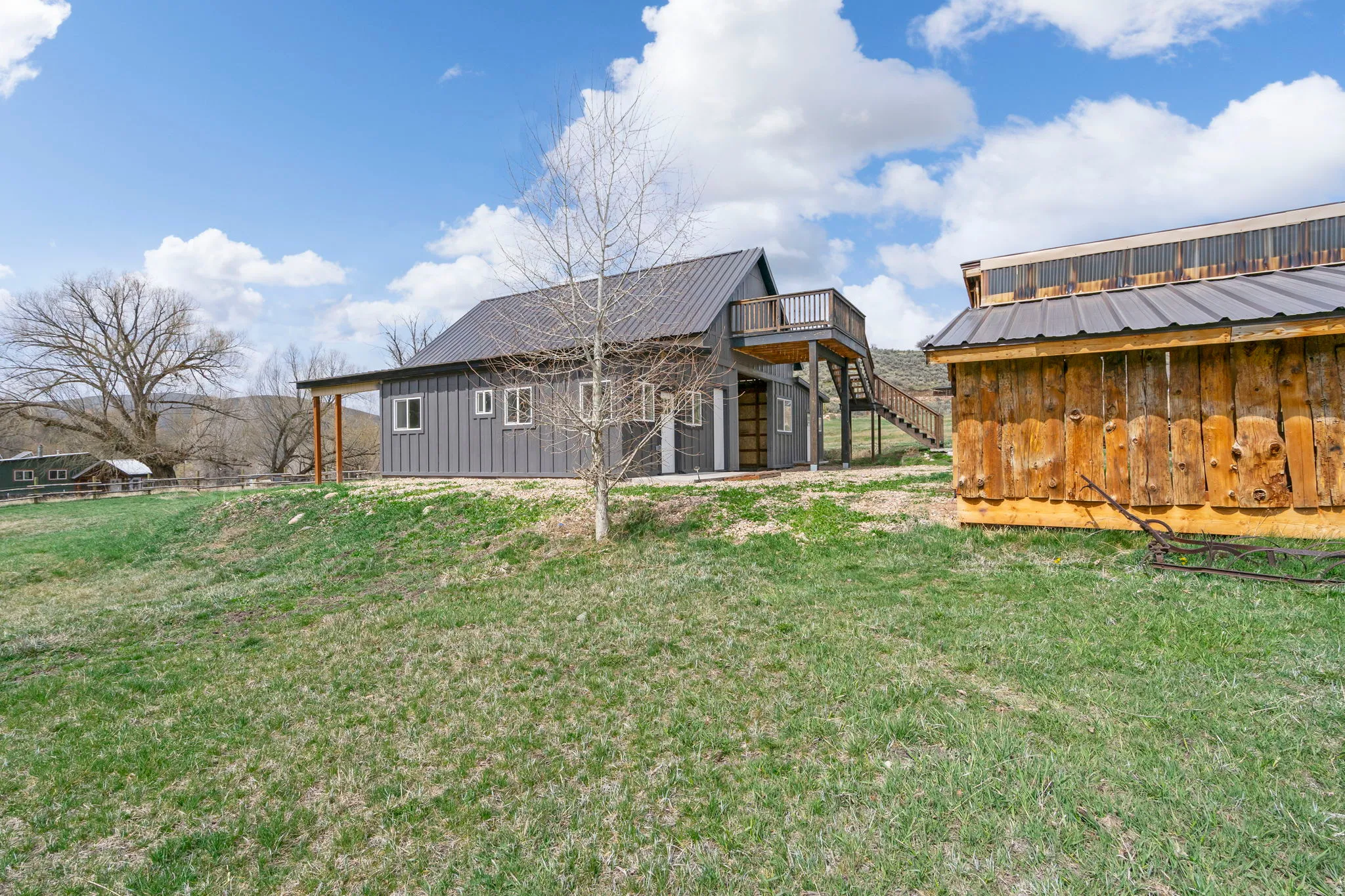 Back of house with a metal roof, a yard, a patio area, and board and batten siding