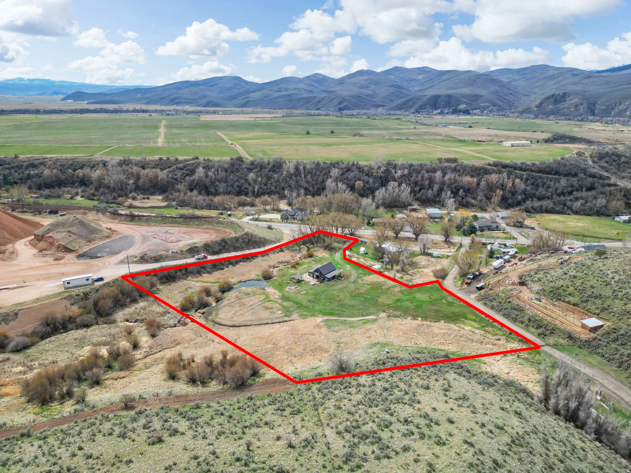 Overview of rural landscape featuring property boundaries highlighted and a mountain backdrop