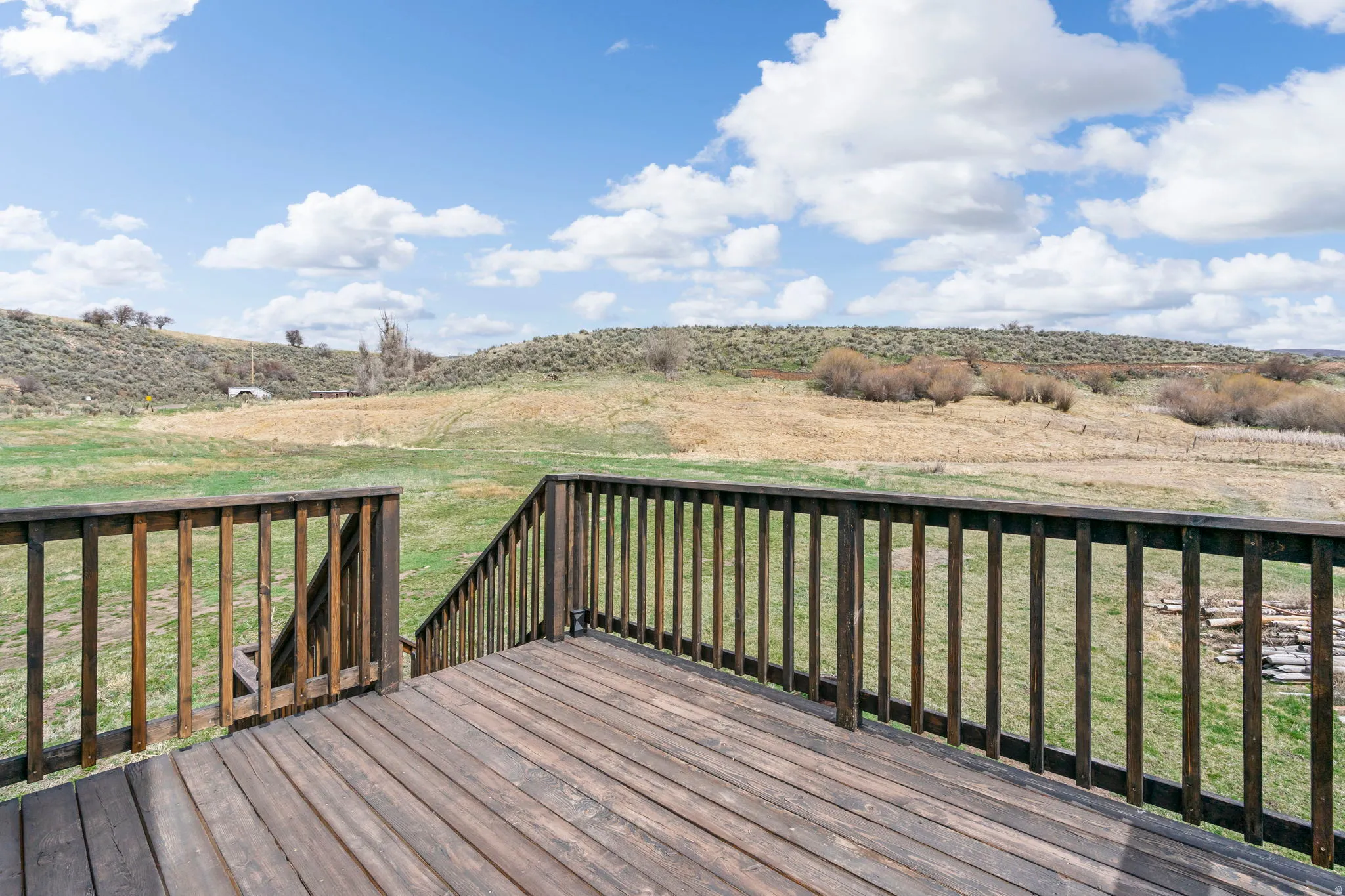 Wooden terrace with a view of countryside and a lawn