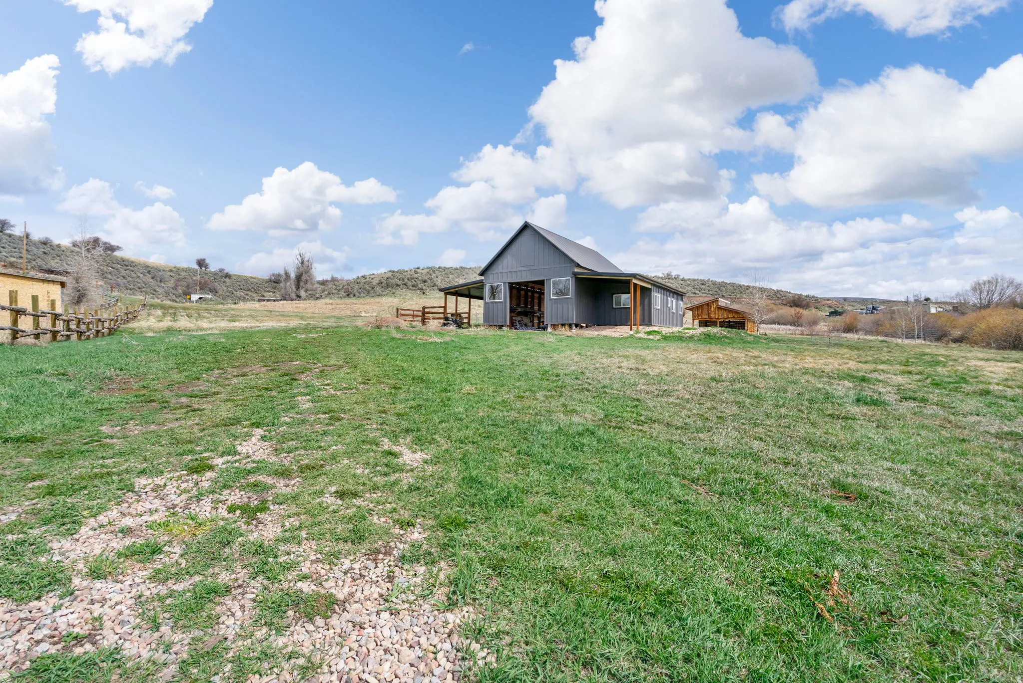 View of grassy yard featuring a rural view and an outdoor structure