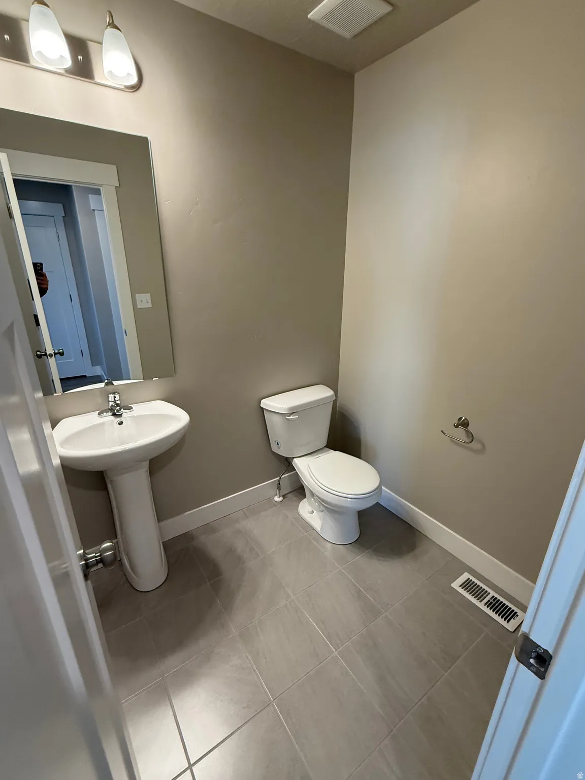 Half bathroom featuring toilet and light tile patterned floors