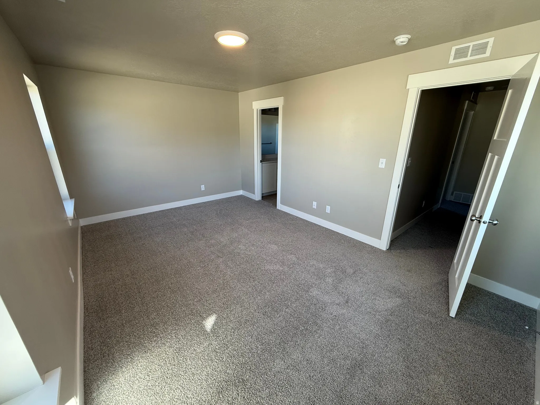 Unfurnished bedroom featuring light colored carpet and baseboards