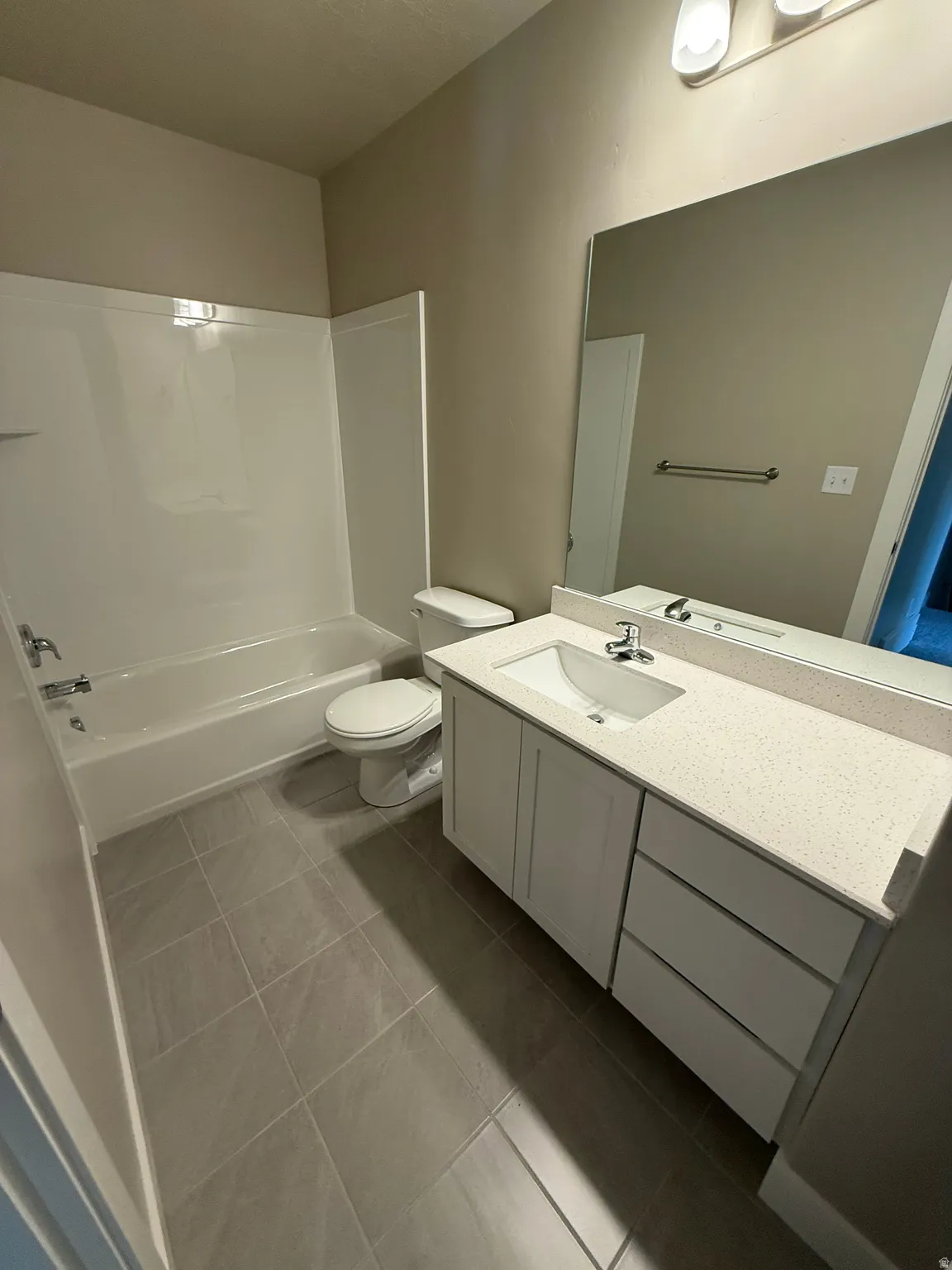 Bathroom with vanity,  shower combination, and dark tile patterned flooring