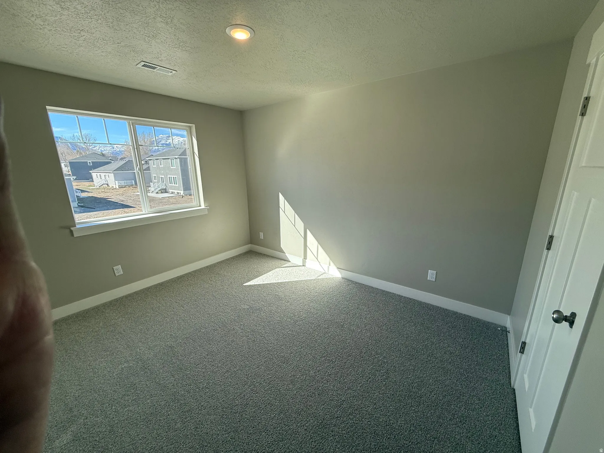 Unfurnished bedroom with carpet and a textured ceiling