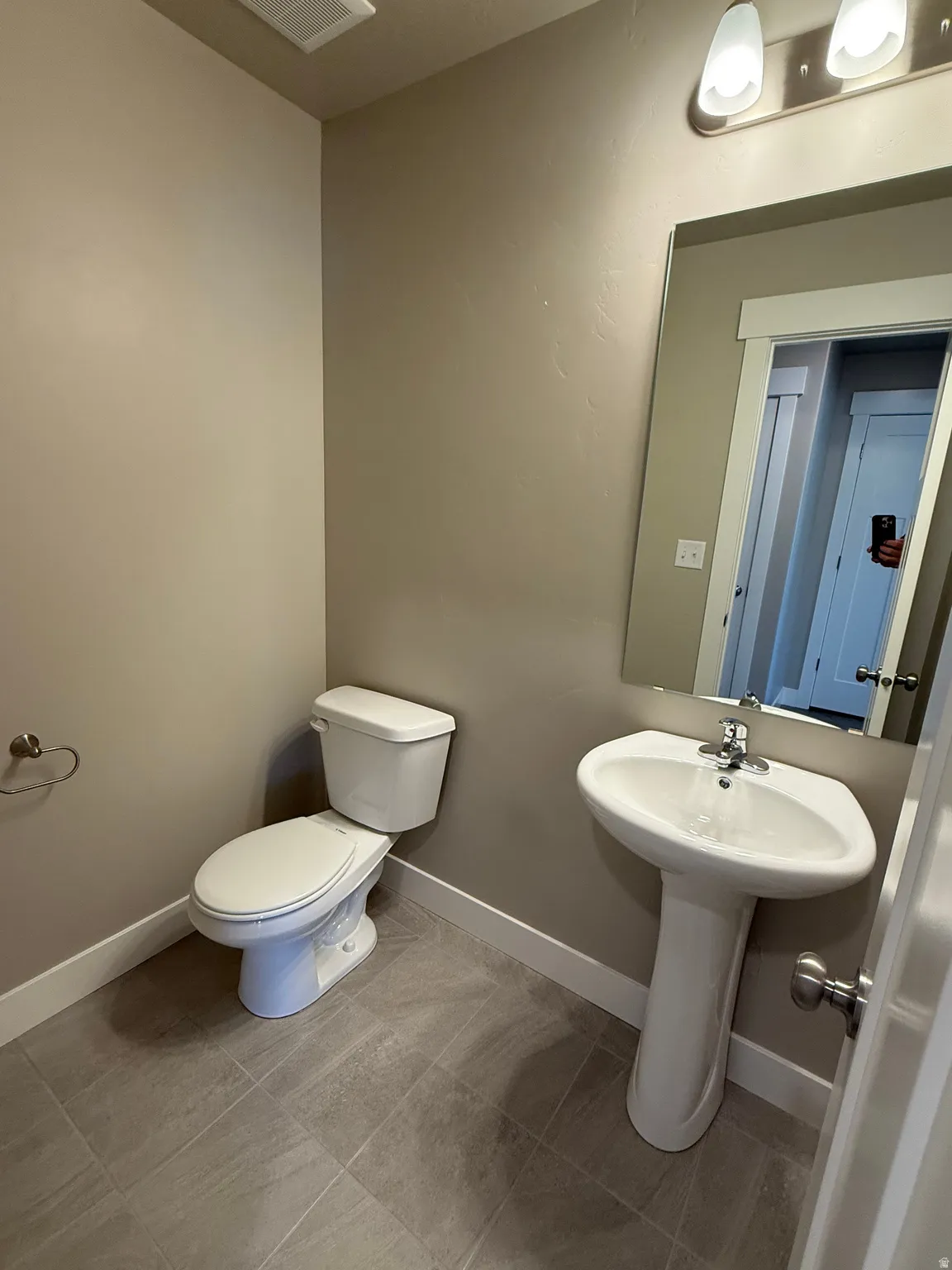 Half bath featuring toilet and baseboards