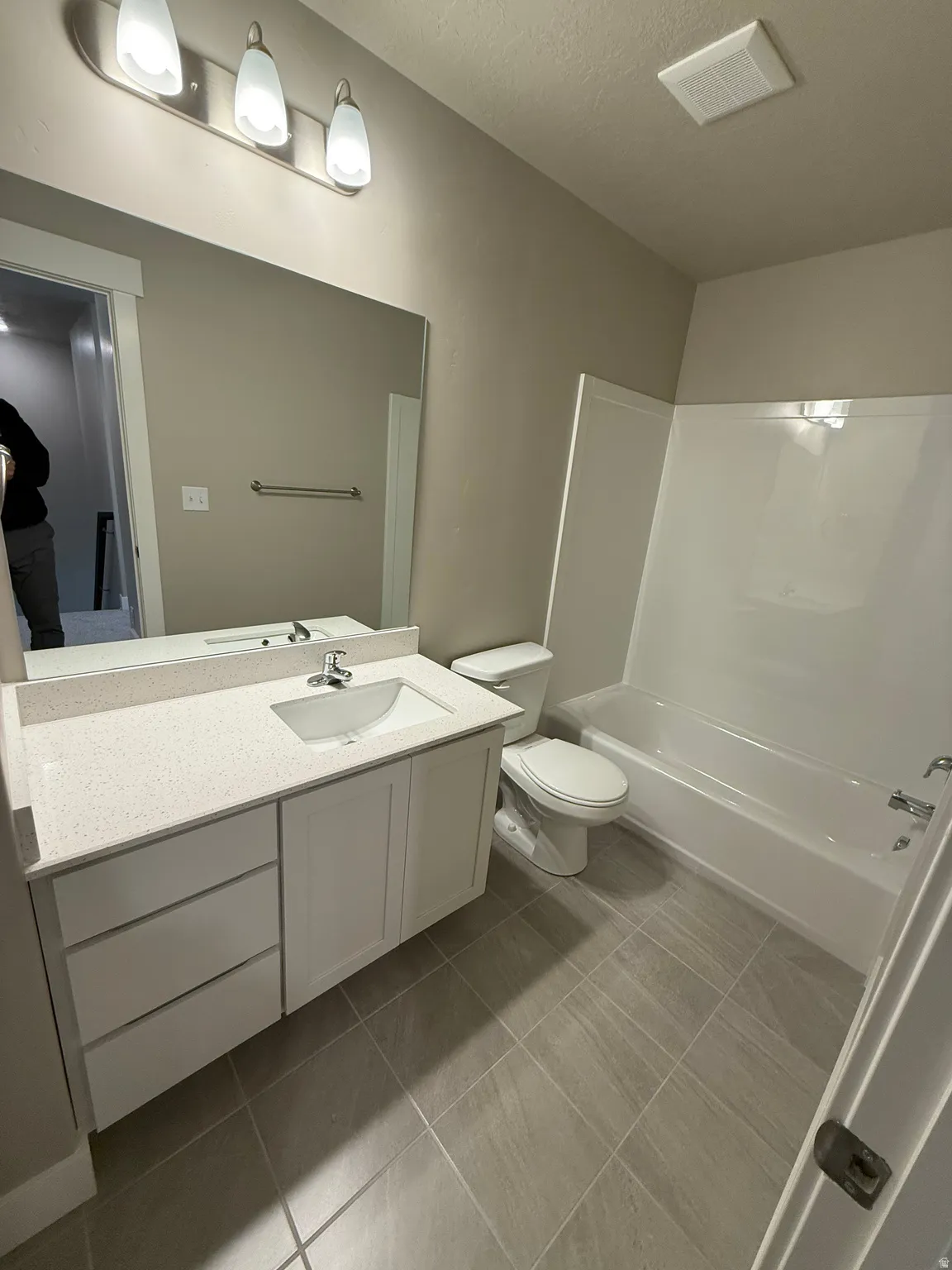 Full bath featuring vanity, shower / washtub combination, and a textured ceiling