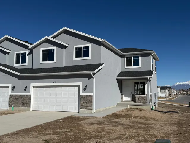 View of front of house with stone siding, concrete driveway, a garage, a mountain view, and a shingled roof