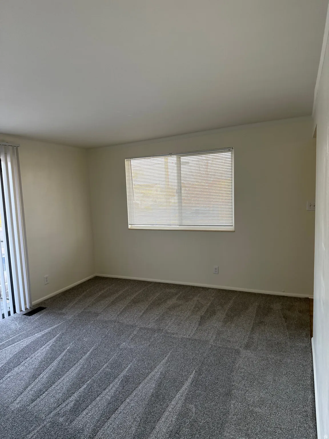 Spare room with dark colored carpet and baseboards