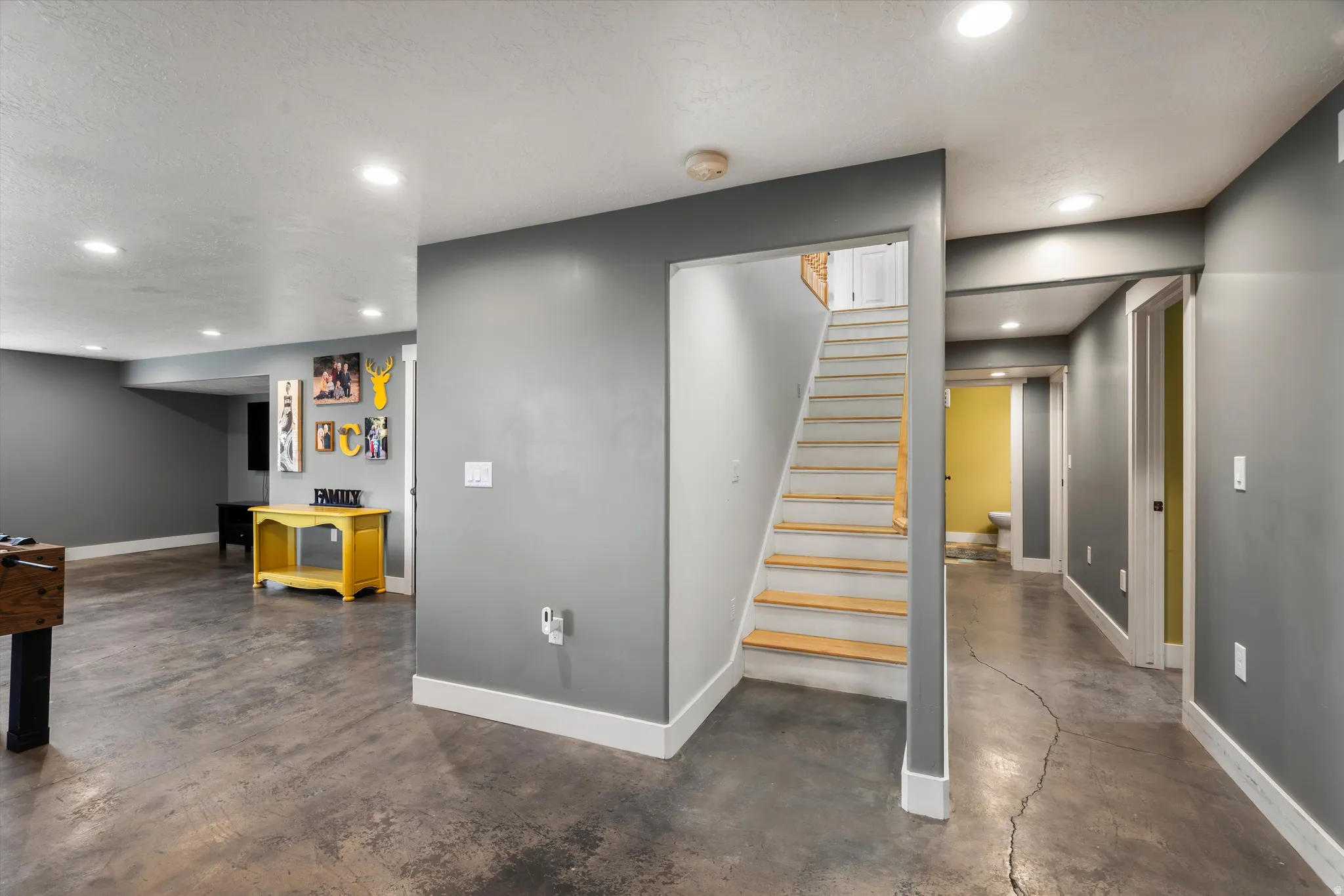 Staircase with concrete flooring and recessed lighting
