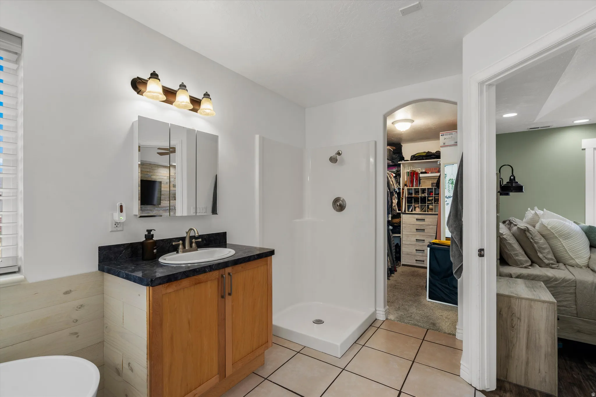 Bathroom with vanity, walk in shower, light tile patterned floors, a spacious closet, and a freestanding tub