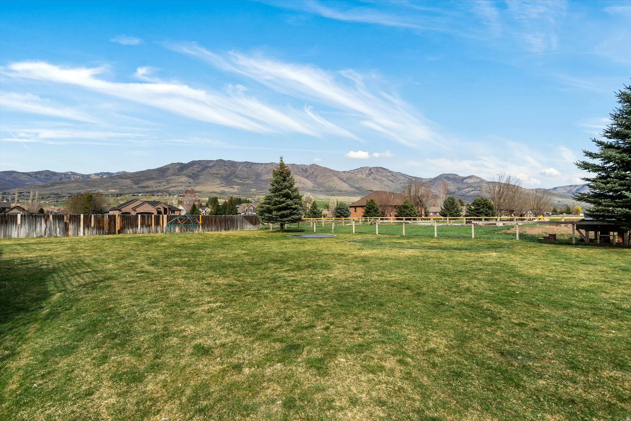 Fenced yard featuring a mountain view and a view of countryside