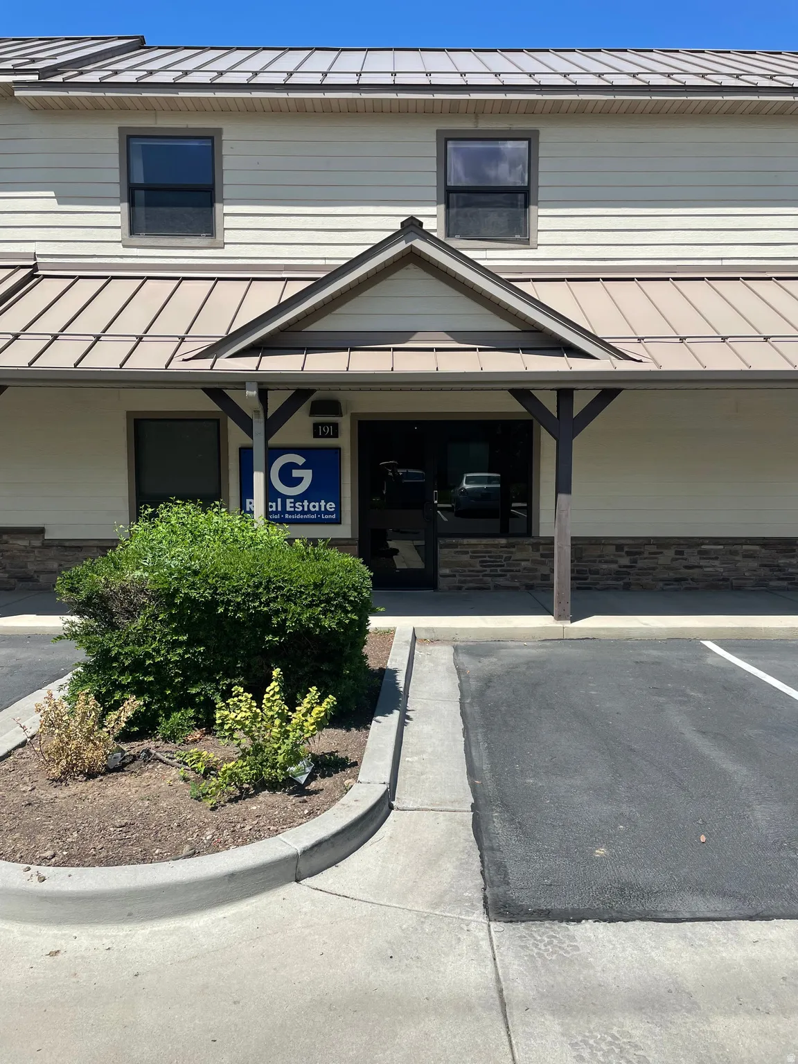 Entrance to property featuring a metal roof and stone siding