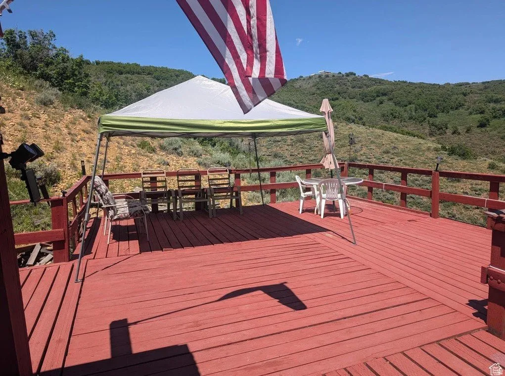 Wooden deck featuring outdoor dining space and a view of trees