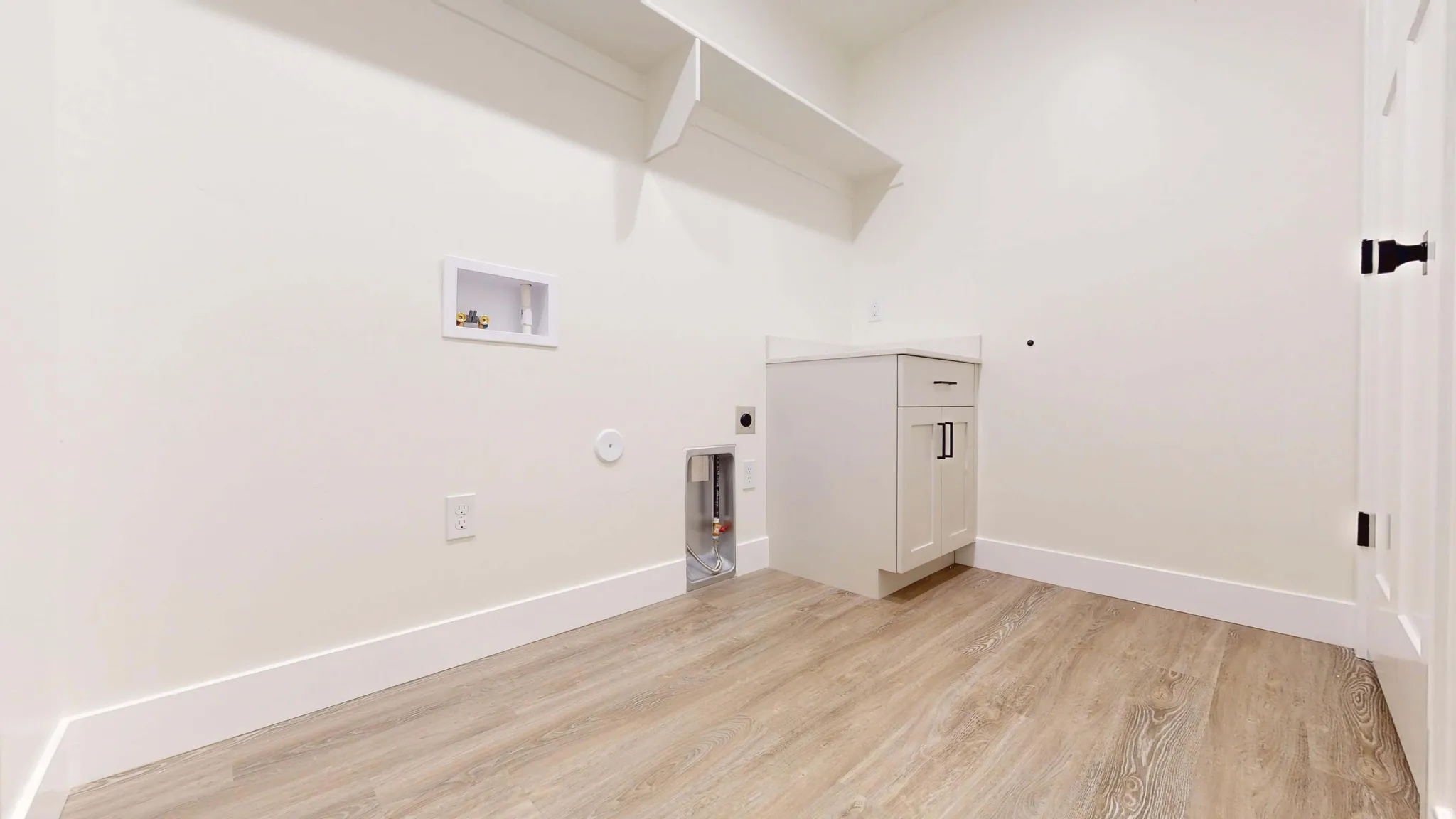 Laundry area featuring hookup for a gas dryer, light wood finished floors, washer hookup, and hookup for an electric dryer