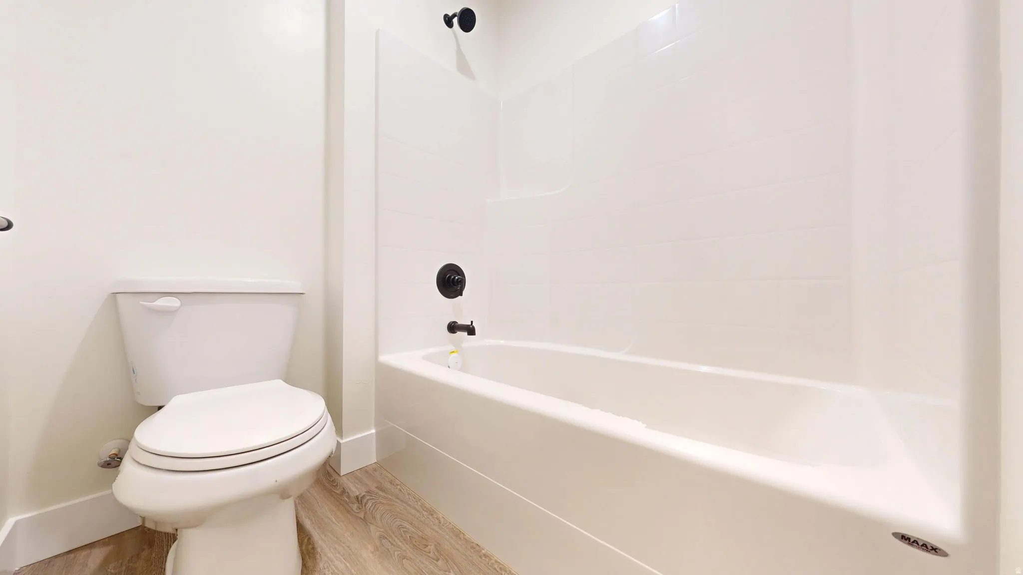 Bathroom with light wood finished floors and shower / bathtub combination