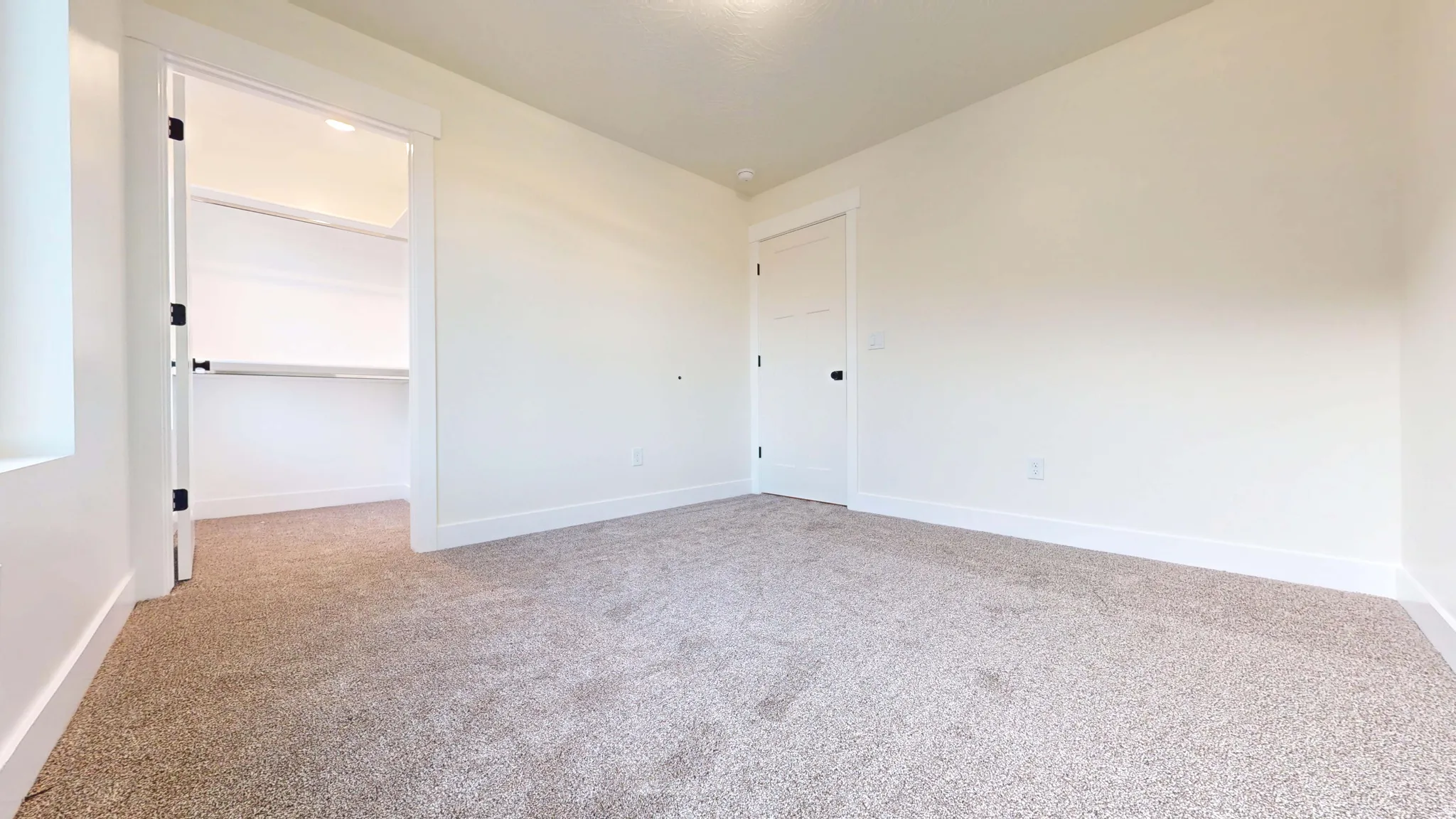Spare room featuring light carpet and baseboards