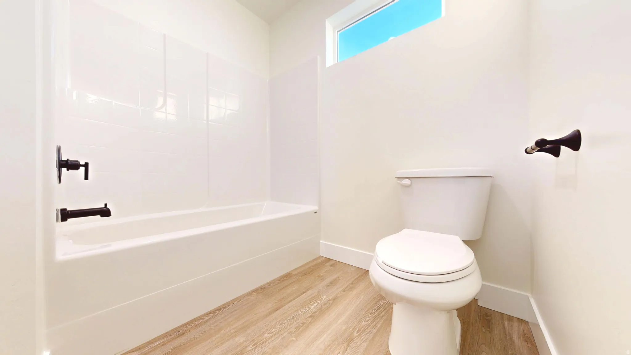 Full bath featuring light wood-style flooring and toilet
