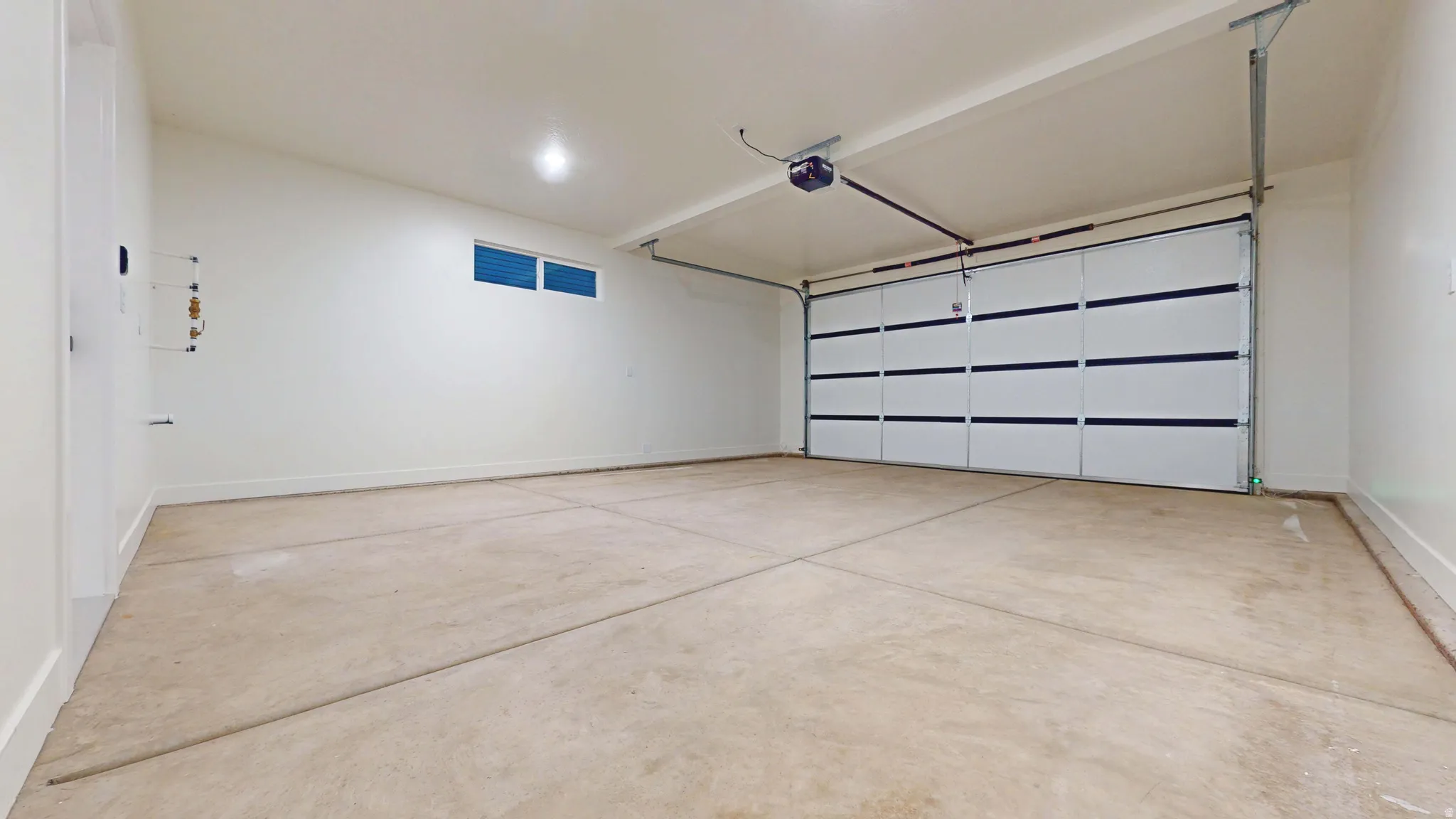 Garage featuring baseboards and a garage door opener