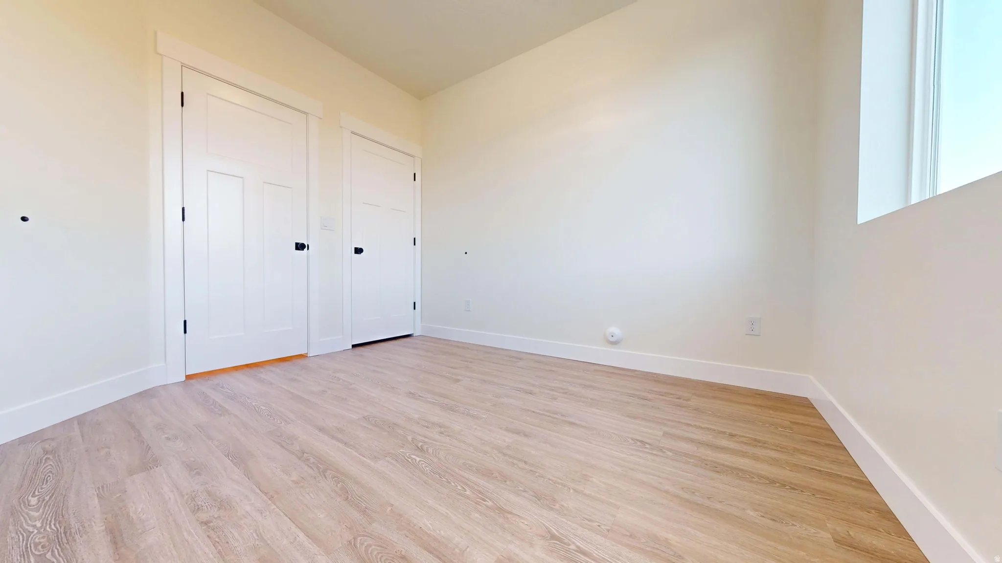 Unfurnished bedroom with light wood-style flooring