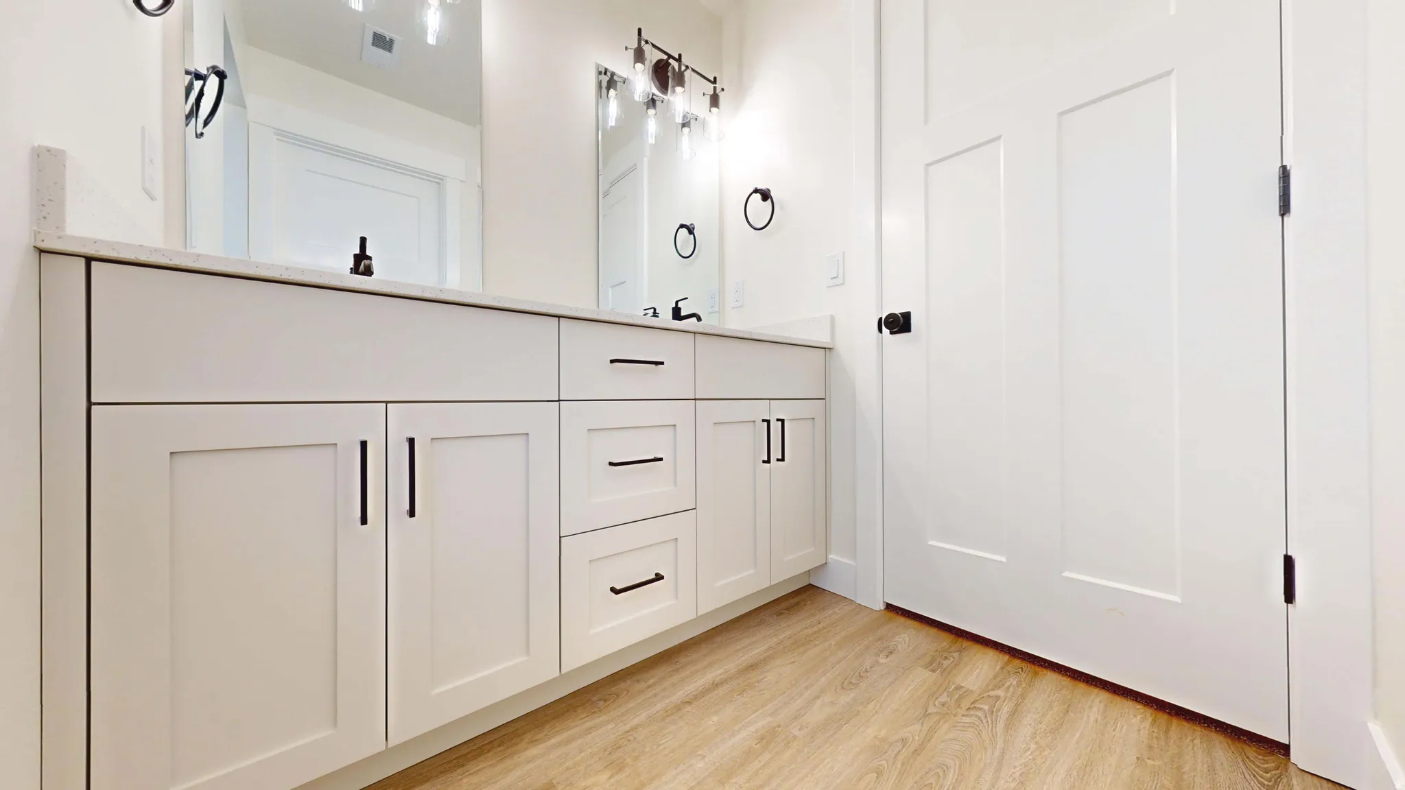 Bathroom with light wood-style floors and double vanity