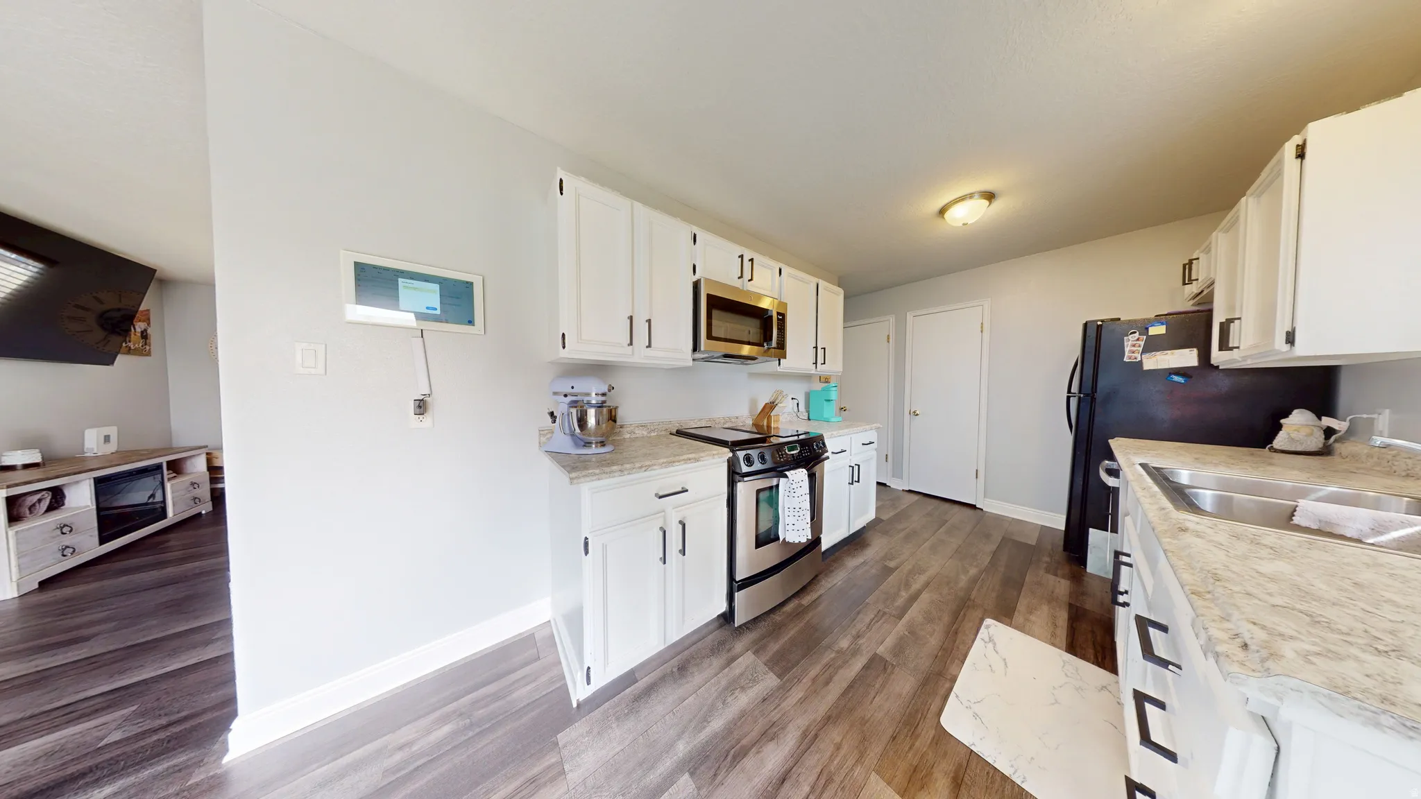 Kitchen with light countertops, white cabinets, and stainless steel appliances