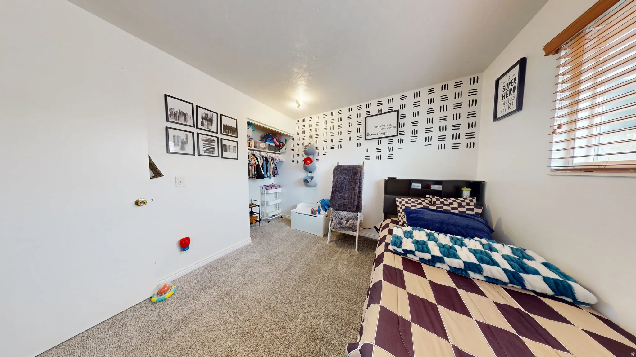 Bedroom with light carpet and a closet