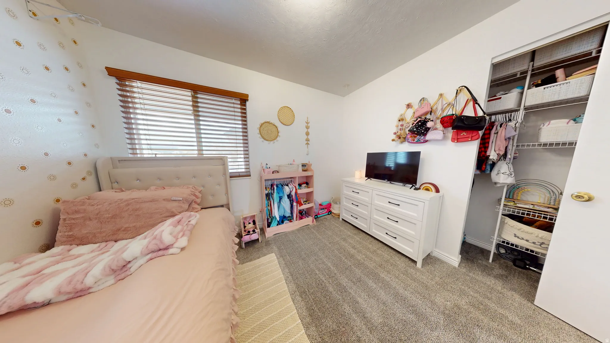 Bedroom with light colored carpet and a closet