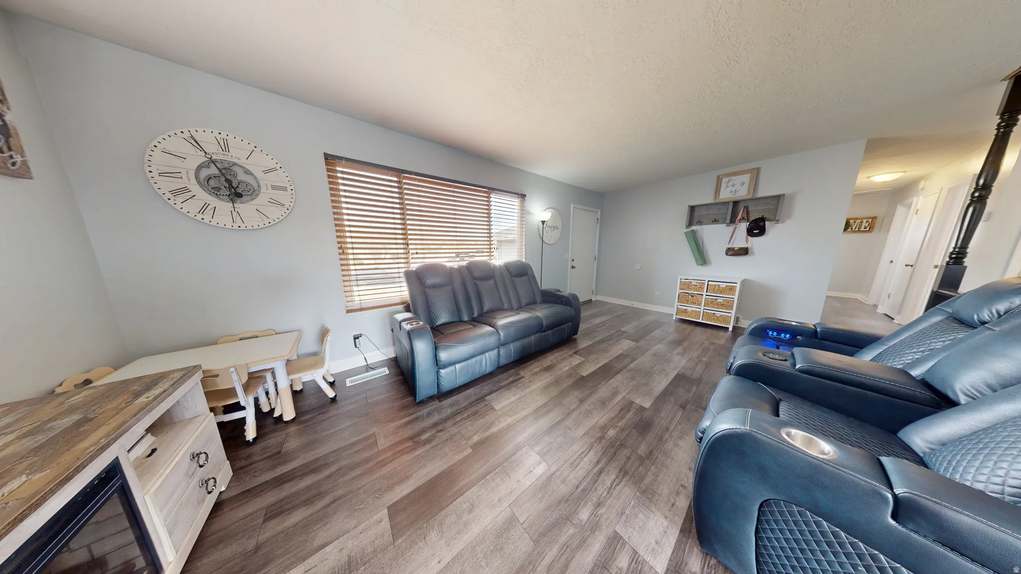 Living area featuring dark wood-style flooring and a textured ceiling