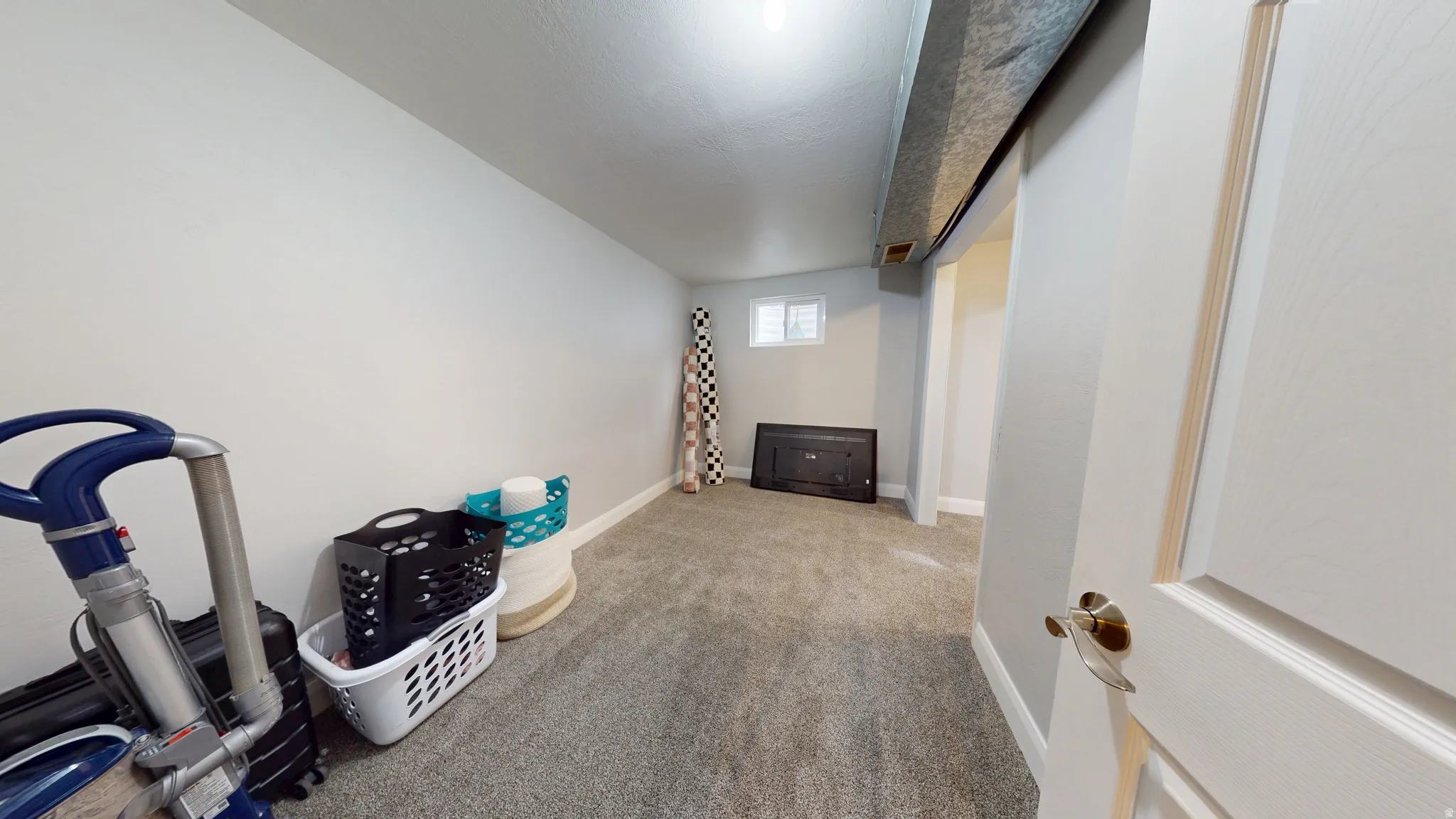 Below grade area featuring light colored carpet and baseboards