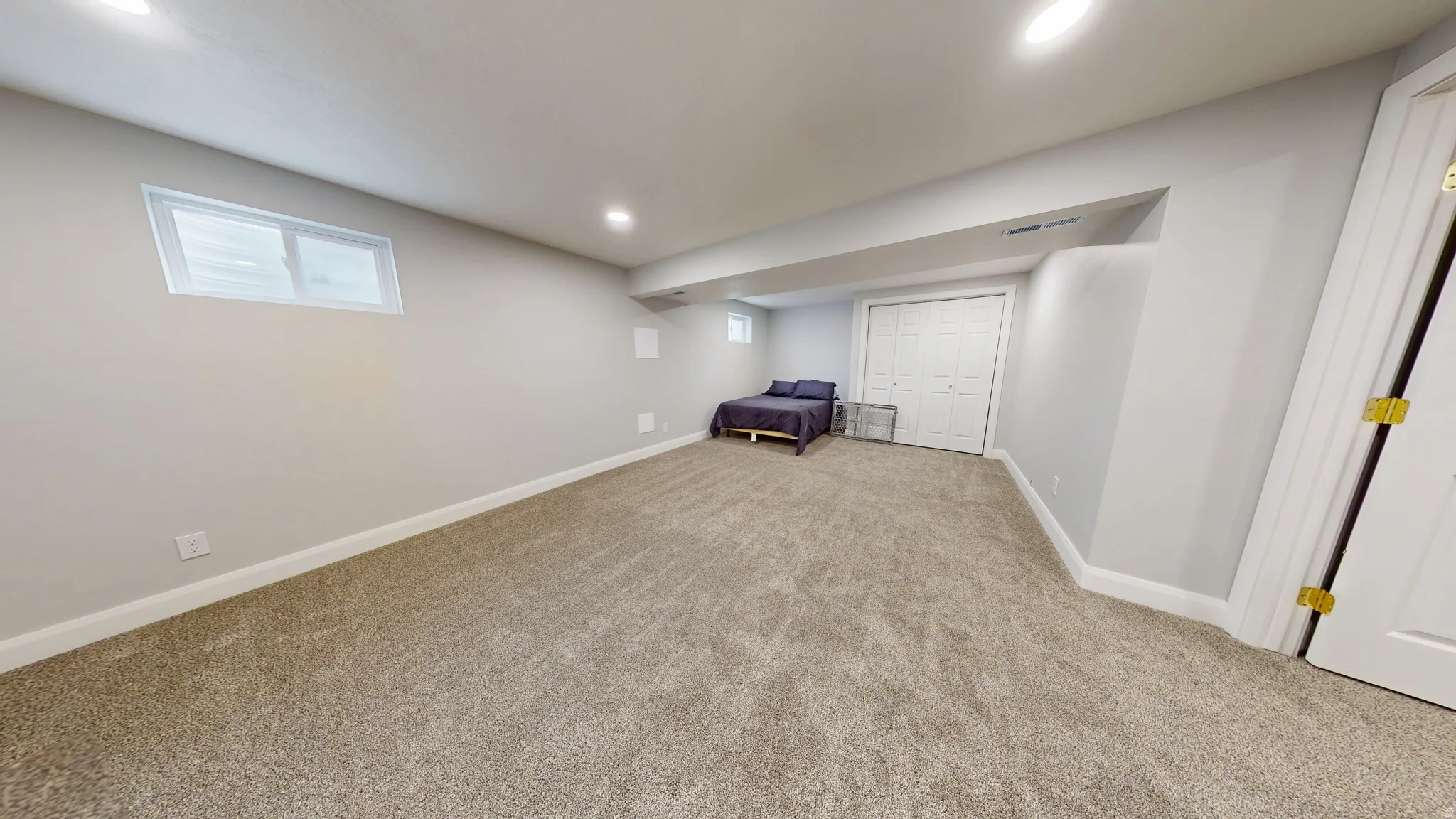 Below grade area with light colored carpet and recessed lighting