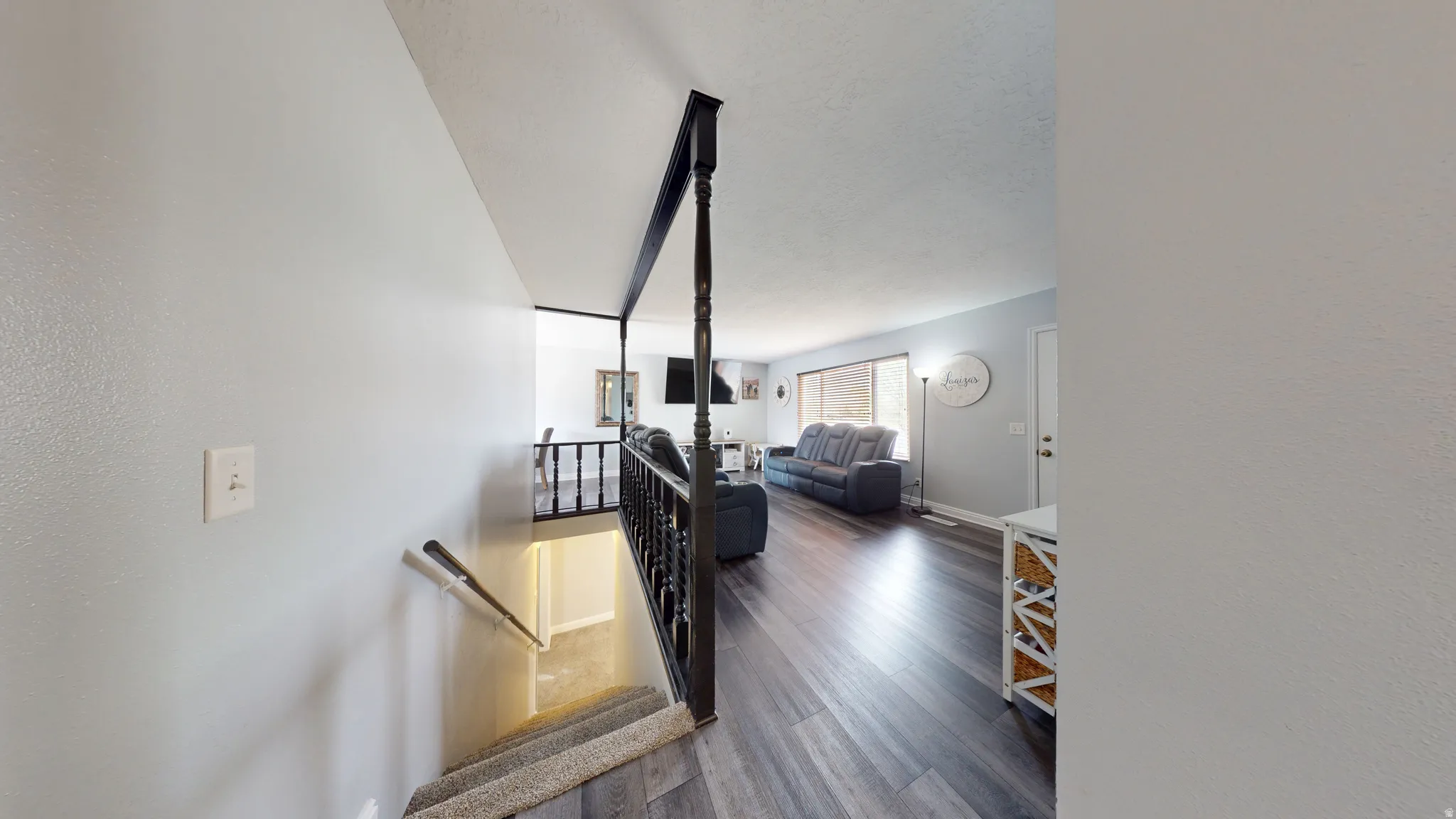 Living room featuring dark wood-style flooring and baseboards