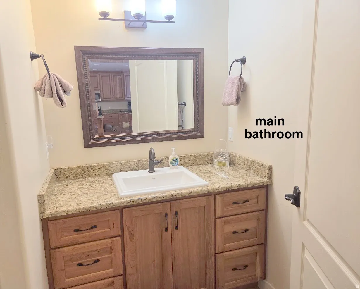 Bathroom vanity featuring a light wood-finish cabinet with multiple drawers and double doors