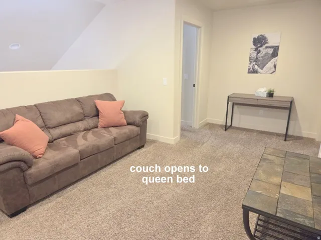Game & TV room featuring light carpet and lofted ceiling