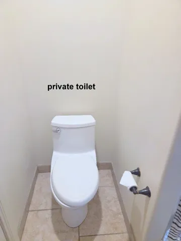 Master ensuite bathroom with baseboards and light tile patterned floors