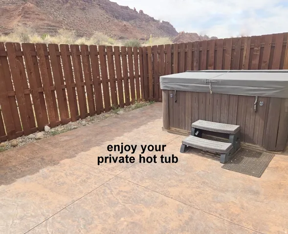 Fenced backyard with a mountain view and a hot tub