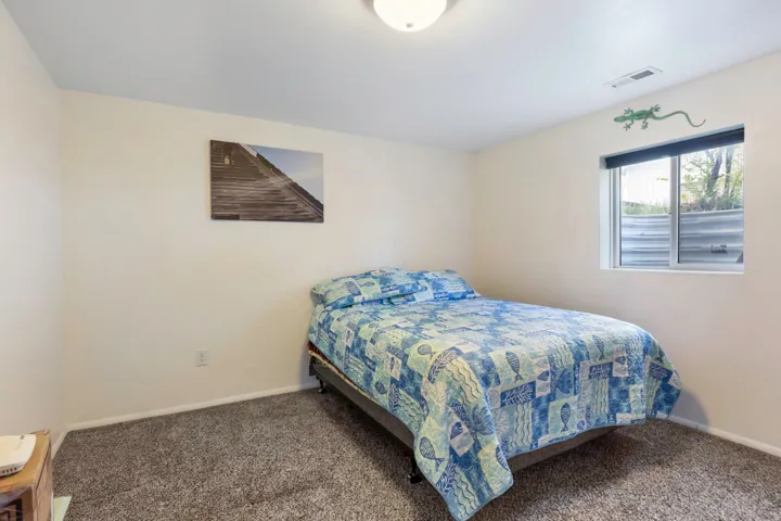 Bedroom featuring dark colored carpet and baseboards