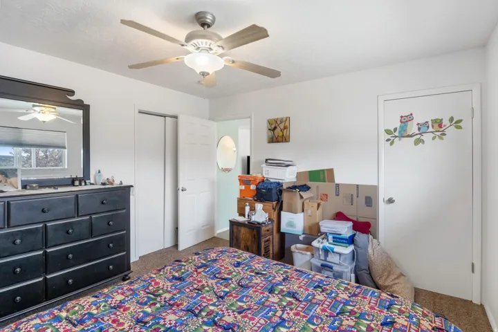 Bedroom with dark carpet and ceiling fan