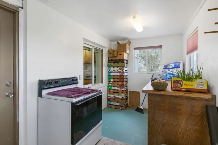 Kitchen with white electric range oven and finished concrete flooring
