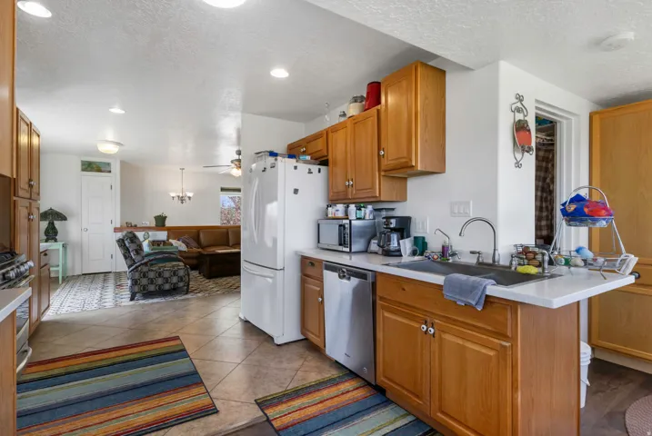 Kitchen with light countertops, a textured ceiling, wood finish cabinets, stainless steel appliances, and recessed lighting