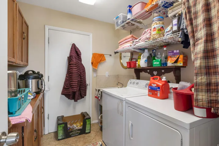 Laundry area featuring separate washer and dryer and light tile patterned floors