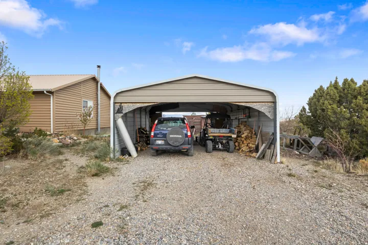 View of outbuilding featuring a carport and driveway
